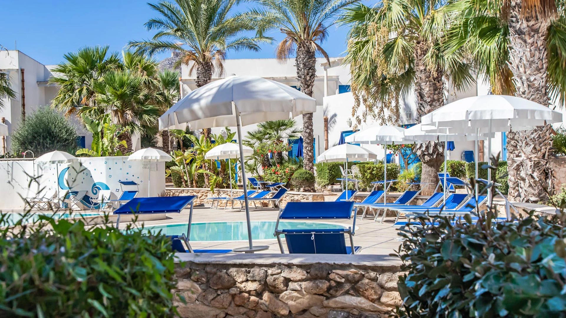 Lettini e ombrelloni accanto alla piscina di Cala La Luna